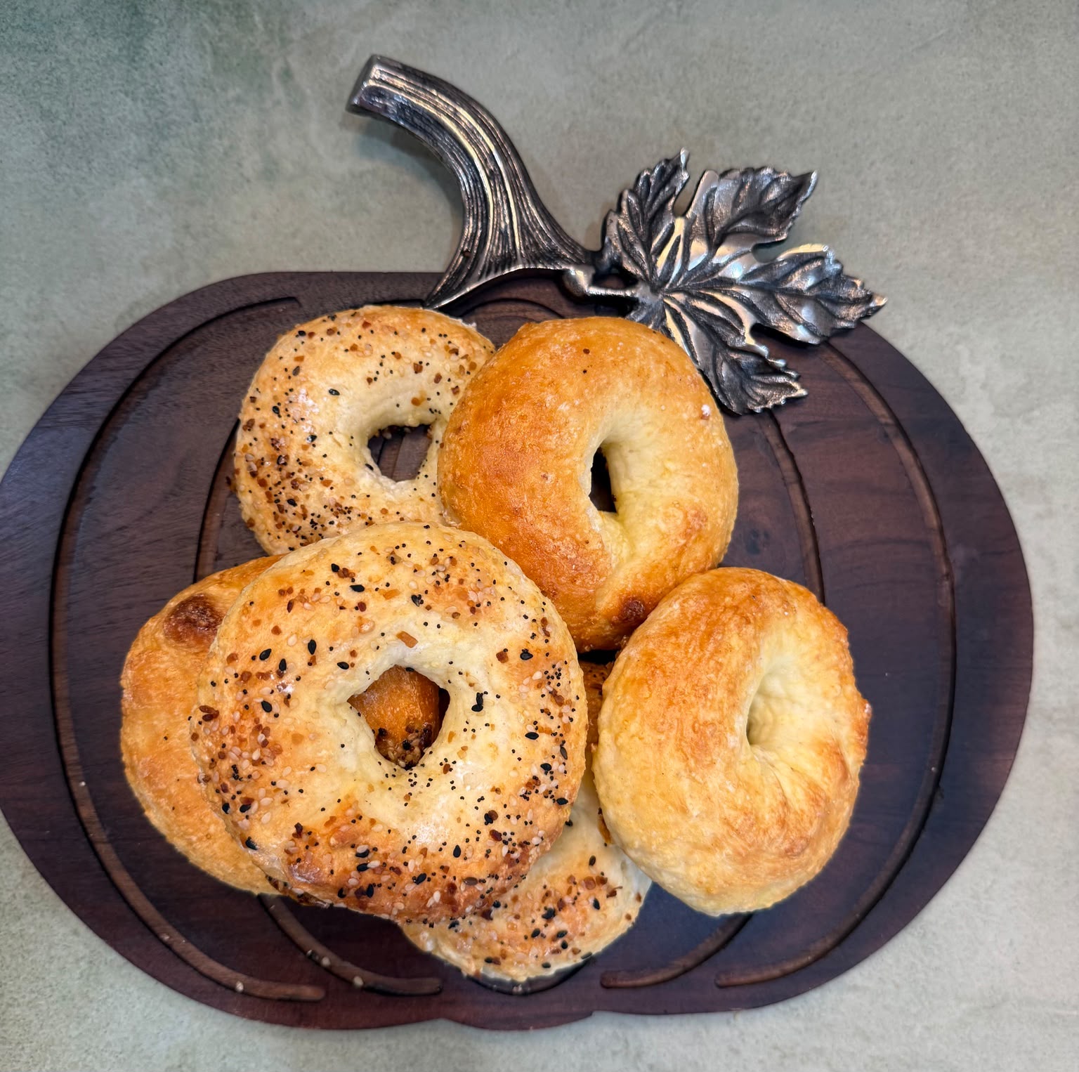 Bagels arranged on a pumpkin-shaped wooden board