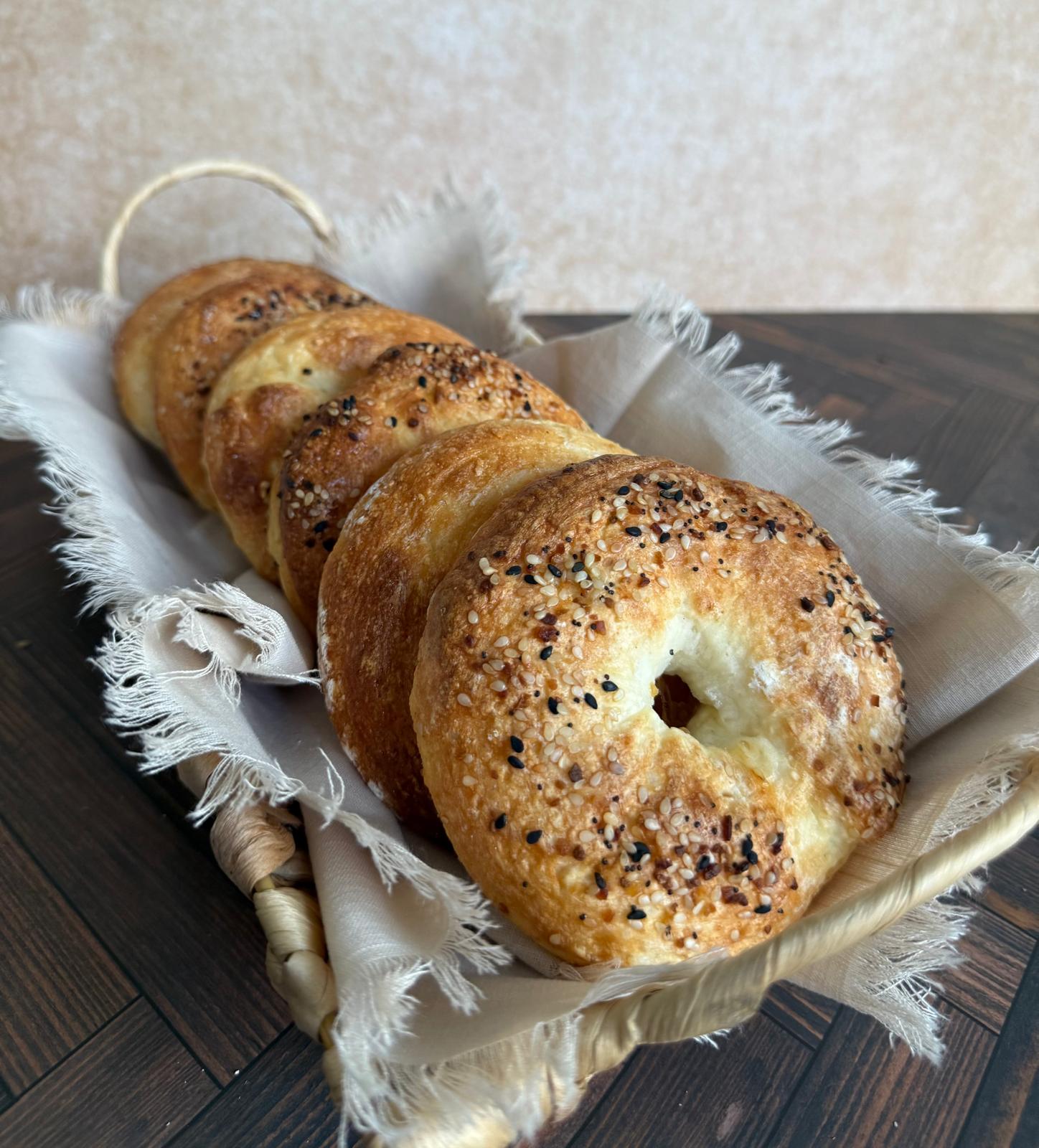 Everything bagels lined up in a linen-lined basket