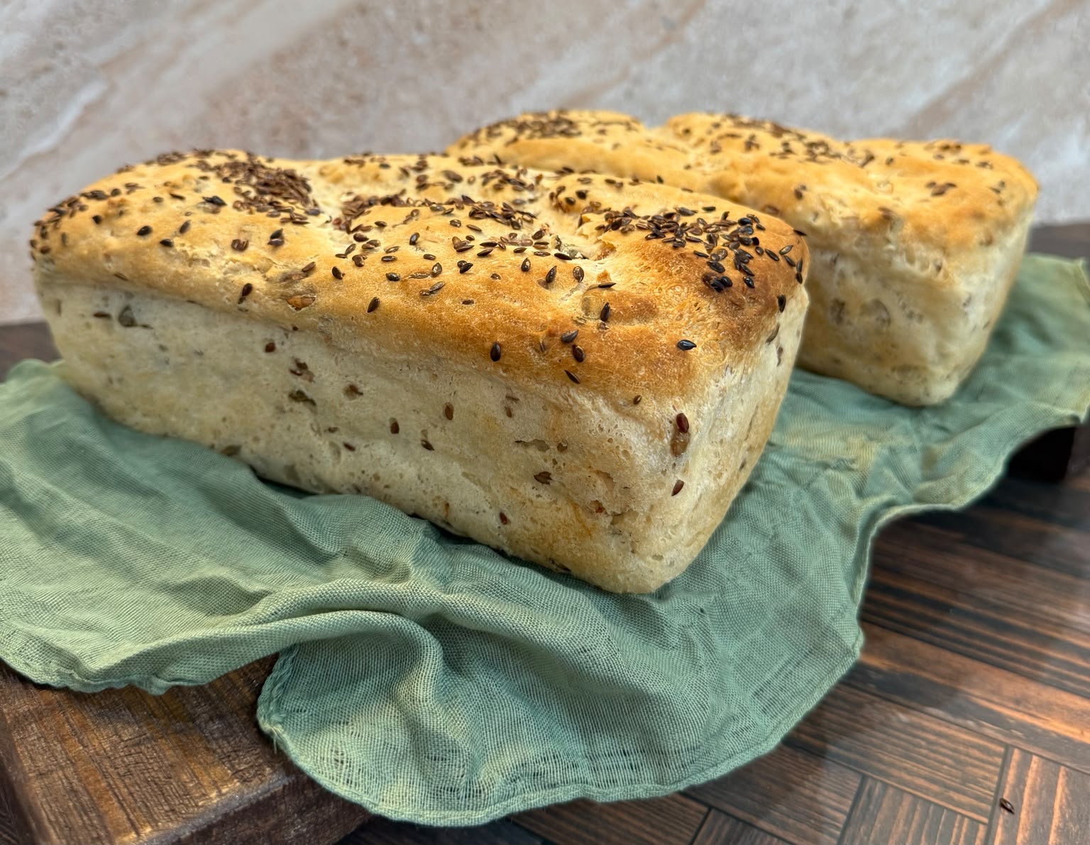 Seeded gluten-free loaves on a green cloth