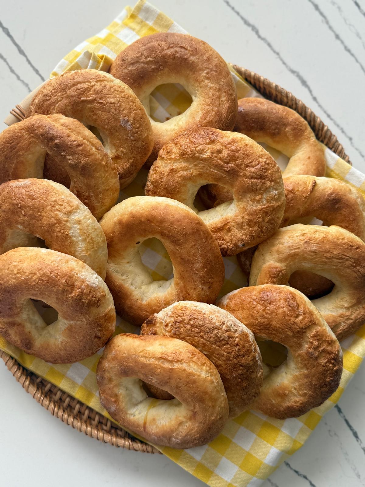 Fresh gluten-free bagels in a basket on marble