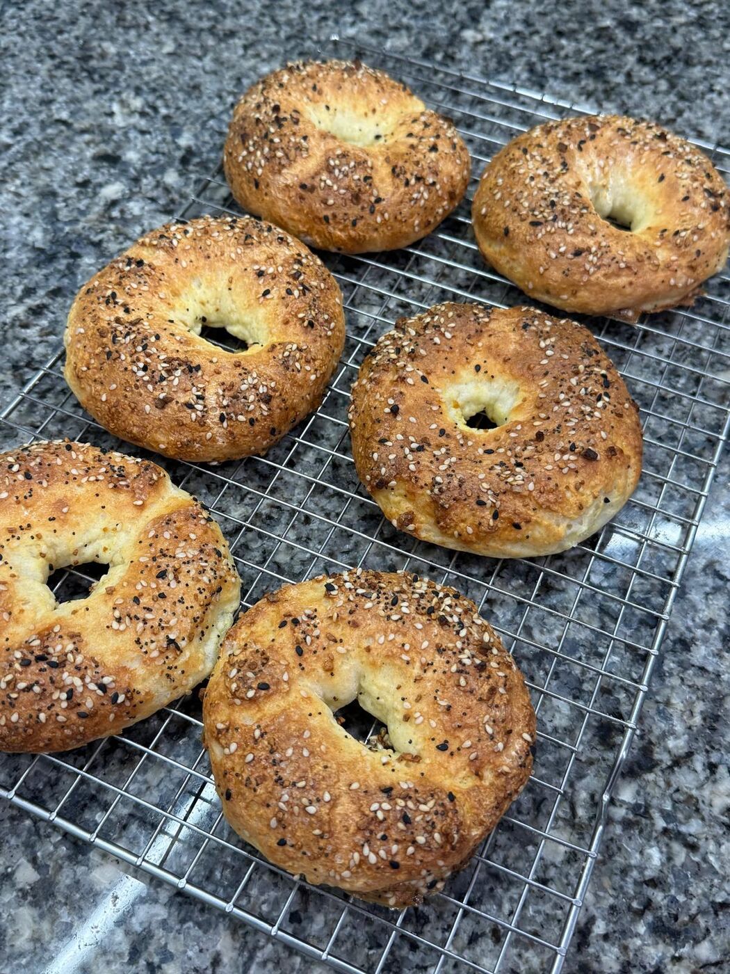 Everything bagels cooling on a wire rack