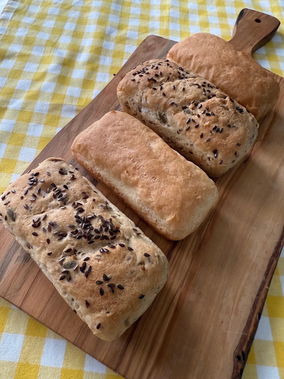 Seeded gluten-free artisan loaves on a wooden board