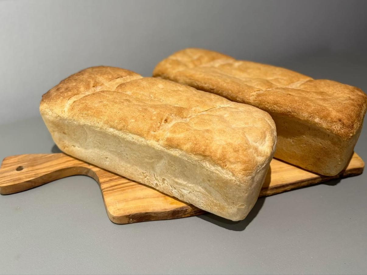 Plain and seeded gluten-free loaves on a wooden board