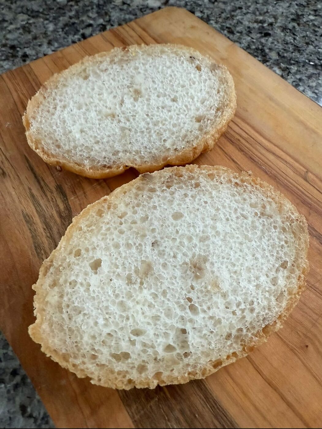 A gluten-free roll cut open showing a soft, airy crumb