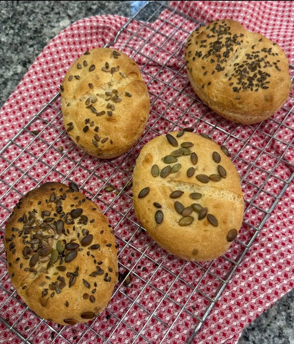 Seeded gluten-free rolls cooling on a rack